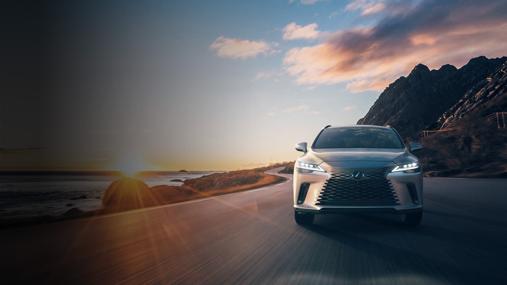 Lexus RX cruising down a road against the setting sun